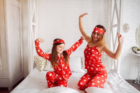 Cute mother and daughter at home in a pajamasの写真素材