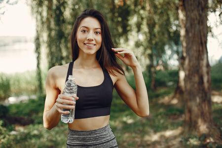 Beautiful sports girl in a summer parkの写真素材