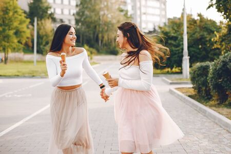 Two pretty girls in a summer parkの写真素材