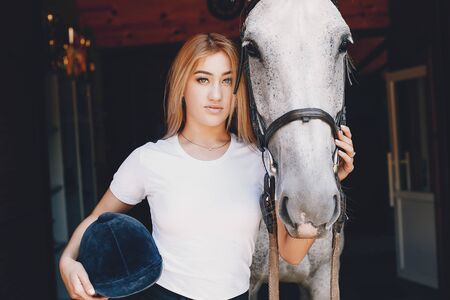 Elegant girl in a farm wiith a horseの写真素材