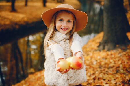 Cute little girl in a autumn parkの写真素材