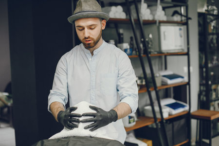The man cuts his beard in the barbershop