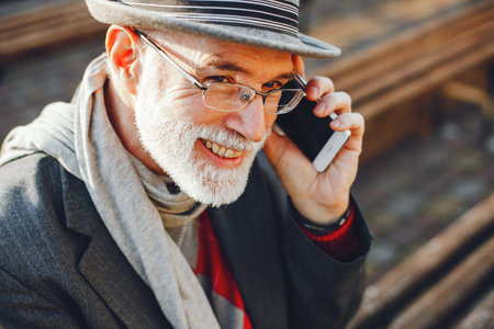 Elegant old man in a sunny autumn park