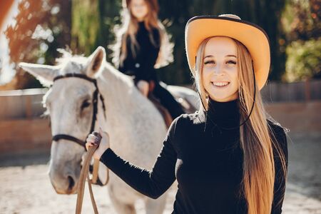 Elegant girls with a horse in a ranchの写真素材