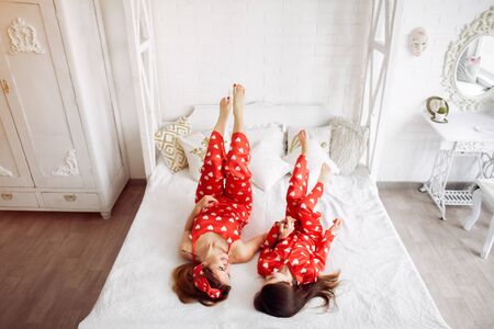 Cute mother and daughter at home in a pajamasの写真素材