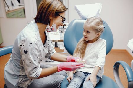 Cute little girl sitting in the dentists officeの写真素材