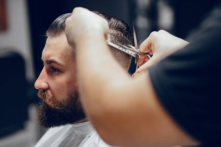 Stylish man sitting in a barbershopの写真素材