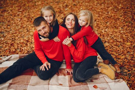 Family with cute kids in a autumn parkの写真素材