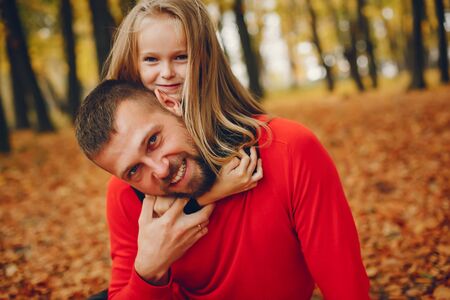 Cute family playing in a autumn parkの写真素材