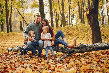 Family with cute kids in a autumn parkの写真素材