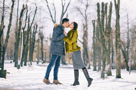 happy couple walking through the park on a sunny winter dayの写真素材