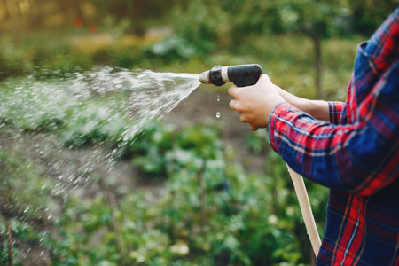 Beautiful woman works in a garden near the house