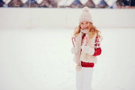 Cute and beautiful little girl in a winter cityの写真素材