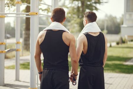 Handsome men in a sports clothes standing in a parkの写真素材