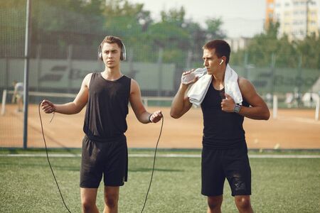 Handsome men in a sports clothes standing in a parkの写真素材
