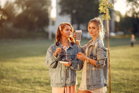 Elegant and stylish girls in a summer parkの写真素材