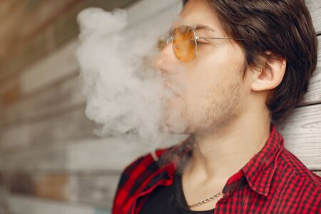 Stylish and elegant man in a city with vapeの写真素材