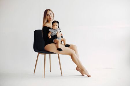 Elegant mother with cute little daughter in a studioの写真素材