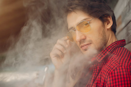 Stylish young couple with vape in a city