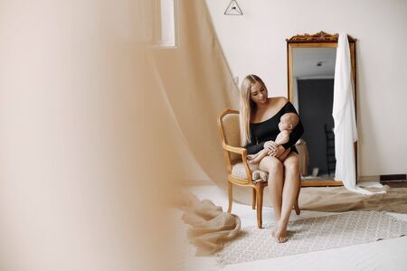 Elegant mother with cute little daughter in a studioの写真素材