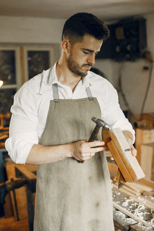 Handsome carpenter working with a wood