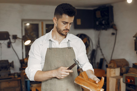 Handsome carpenter working with a wood