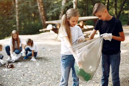 Children collects garbage in garbage bags in parkの写真素材
