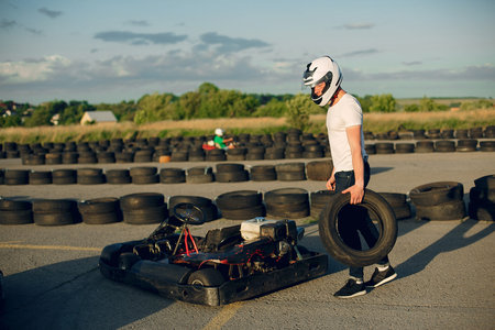 Karting. Man in a white t-shirt. Male with a kart car