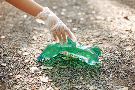 Girl collects garbage in garbage bags in park