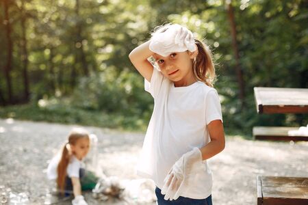 Children collects garbage in garbage bags in parkの写真素材