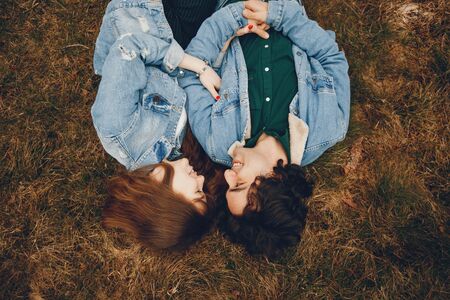 gentle and stylish couple sitting in the autumn parkの写真素材
