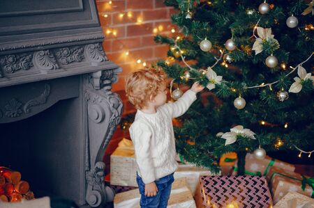 Cutte little boy at home near christmas decorationsの写真素材