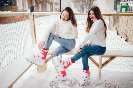 Cute and beautiful girls in a white sweater in a winter cityの写真素材