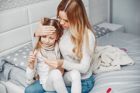Mother with her illnes daughter in a bedroomの写真素材