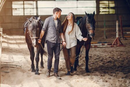 Cute loving couple with horse on ranchの写真素材