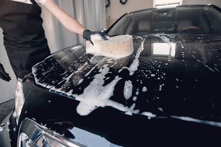 Man washing his car in a garageの写真素材