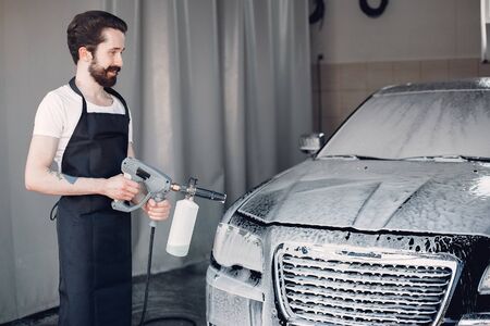 Man washing his car in a garageの写真素材