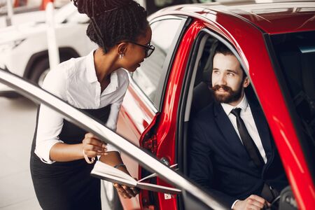 Stylish black woman in a car salonの写真素材