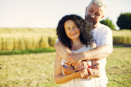 Beautiful adult couple spend time in a summer field