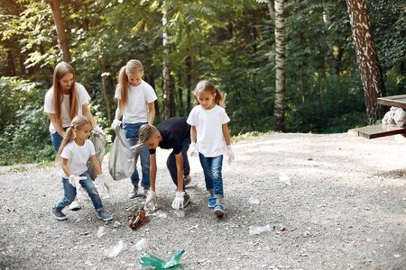Children collects garbage in garbage bags in parkの写真素材