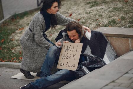 Homeless man in a durty clothes autumn cityの写真素材