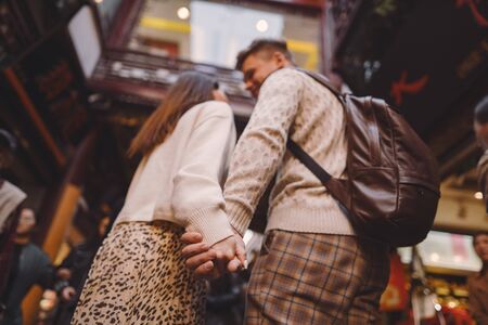 newlywed couple showing affection and holding hands in Shanghai near Yuyuan while visiting Chinaの写真素材