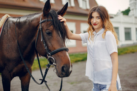 Beautiful woman standing with a horseの写真素材