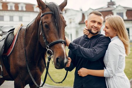 Cute loving couple with horse on ranchの写真素材
