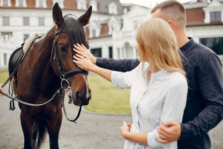 Cute loving couple with horse on ranchの写真素材