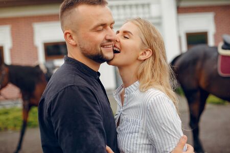 Cute loving couple with horse on ranchの写真素材