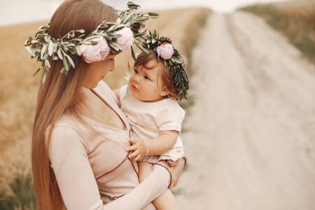 Mother with daughter playing in a summer fieldの写真素材