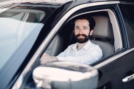 Handsome and elegant man in a car salonの写真素材