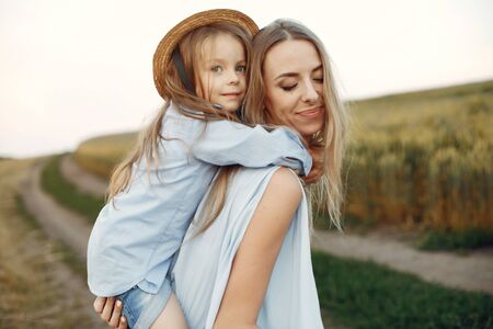 Mother with daughter playing in a summer fieldの写真素材