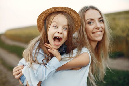 Mother with daughter playing in a summer fieldの写真素材